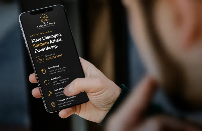Hand mit Telefon, im Display die Website der OCA Bausanierung