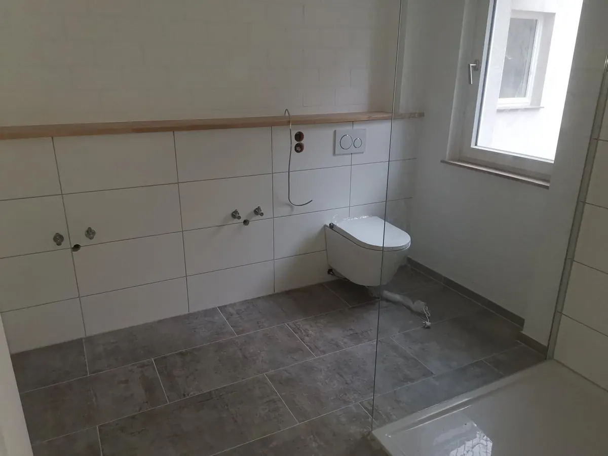 Fertig gefliestes Badezimmer mit Wand-WC