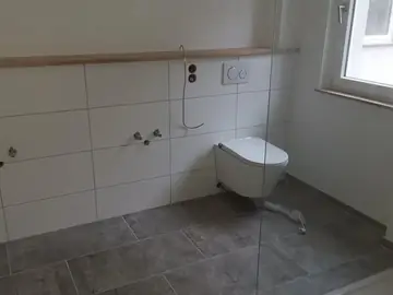 Fertig gefliestes Badezimmer mit Wand-WC
