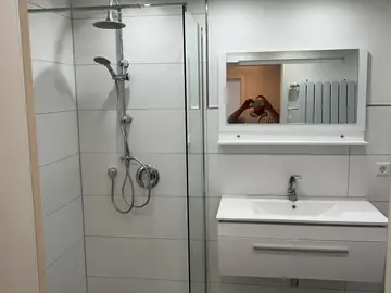 Badezimmer mit Glasdusche und Waschtisch
