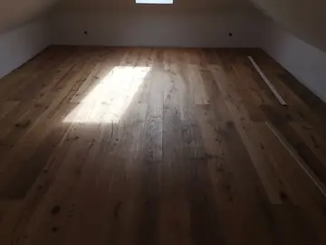 Raum mit dunklem Massivdielenboden
