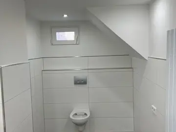 Gäste-WC mit weißen Wandfliesen