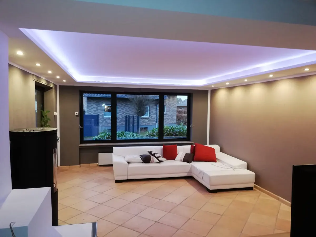 Wohnzimmer mit abgehängter Decke und indirekter LED-Beleuchtung